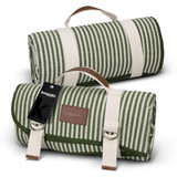 A green and white striped picnic blanket, rolled up with handles, featuring a leather accent and a branding tag.