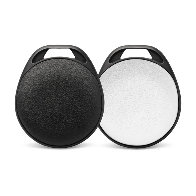 A pair of round Bluetooth trackers in black and white, featuring a textured surface and a hole for attachment.