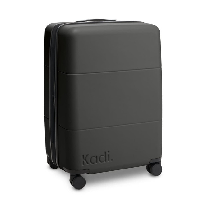 A medium suitcase in black with a textured surface and four wheels, featuring a logo.