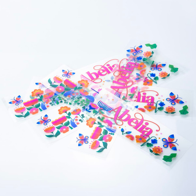 A collection of colourful stickers featuring floral and butterfly designs, displayed against a white background.