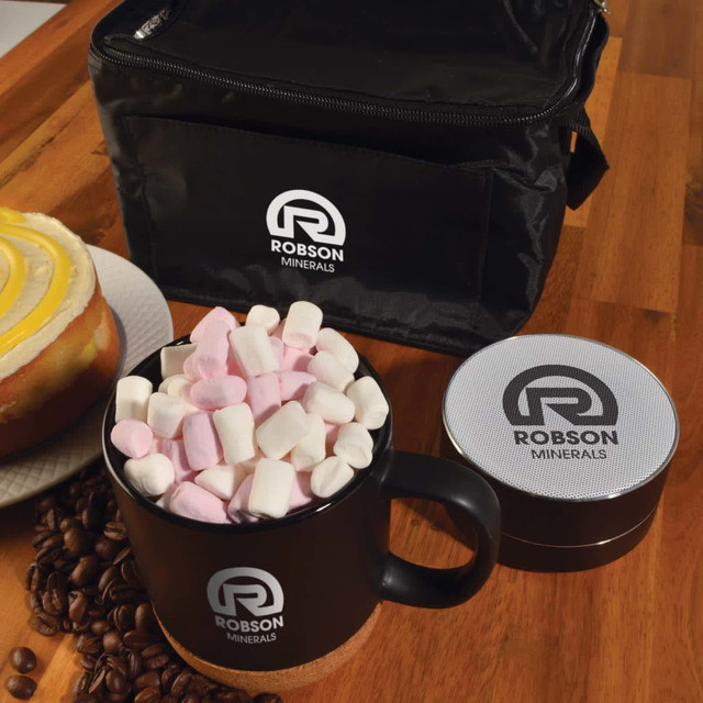 A black coffee mug filled with pink and white marshmallows, next to a silver container and a black bag with a logo.