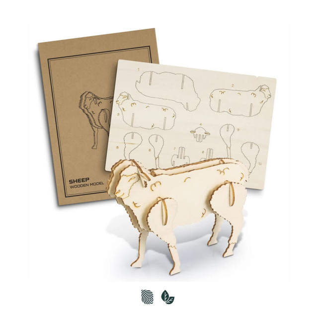 A wooden sheep model in natural wood colour with assembly instructions on a cardboard background.