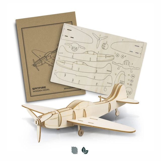 A wooden model of a Spitfire aircraft with laser-cut parts on a backing board, featuring a natural wood finish.