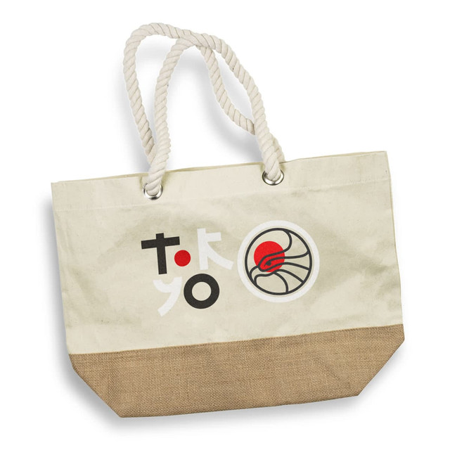 A cream tote bag with a jute bottom, featuring a logo and colourful graphics. It has sturdy rope handles.