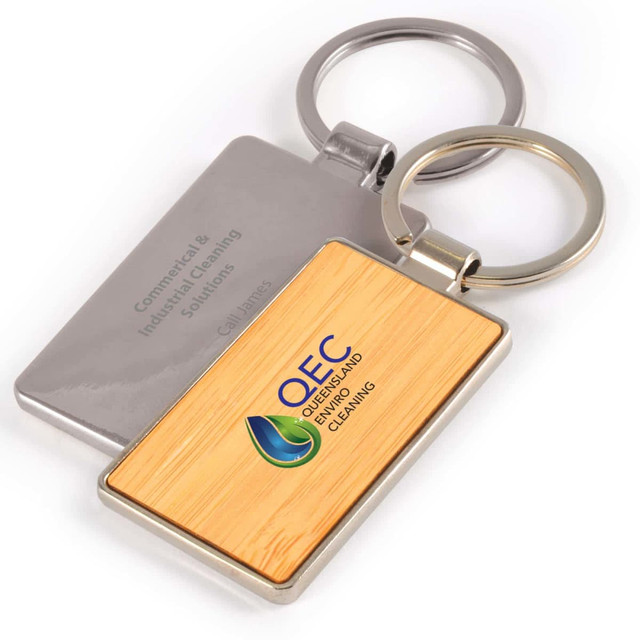 A Rectangle Bamboo Zinc Keytag featuring a bamboo design and a metal backing with a logo.
