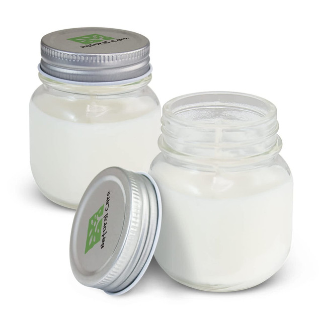Two glass jars of white scented candles with silver lids, featuring a logo on the top of one jar.