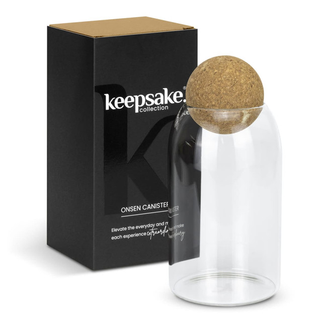 A glass canister with a cork lid, presented with a black box featuring a logo.