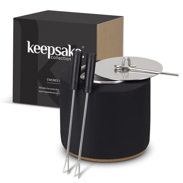 A black keepsake S'mores kit featuring a round container, a lid, and two skewer sticks. The box is also included.