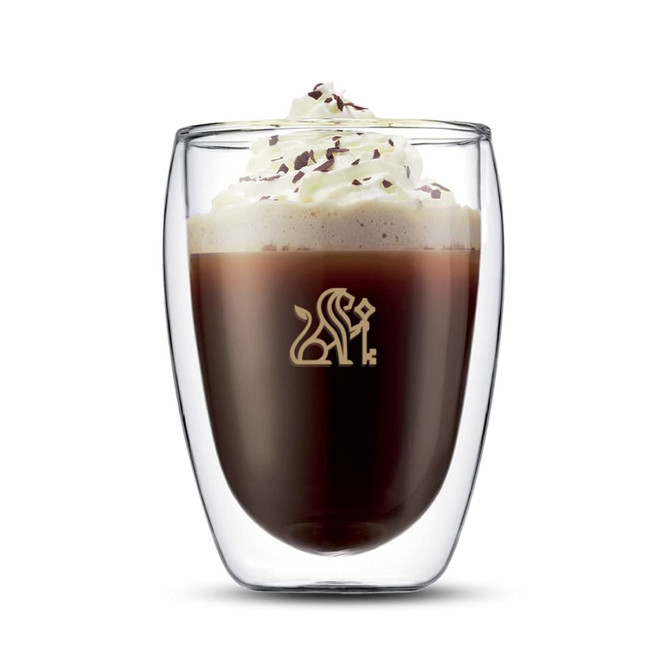 A double wall glass with a beverage topped with whipped cream and chocolate shavings, featuring a logo.