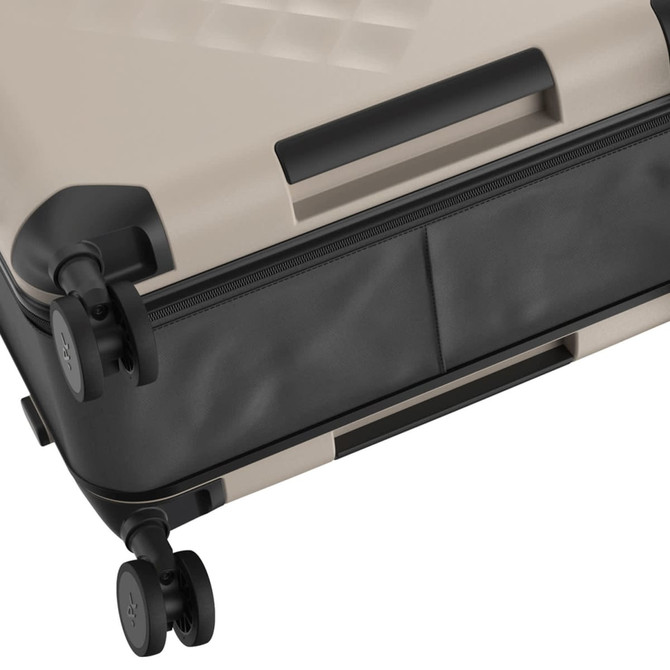A beige and black wheeled suitcase featuring a textured design and dual spinner wheels, with a zipper along the side.