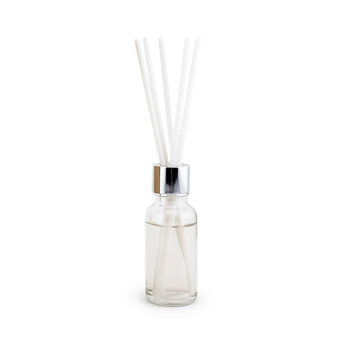 A glass bottle with a silver lid, containing clear liquid and four white reeds for fragrance diffusion.