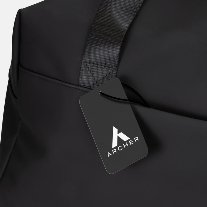A black soft-touch duffle bag featuring a logo and a stylish tag. The bag has a sleek, minimalistic design.