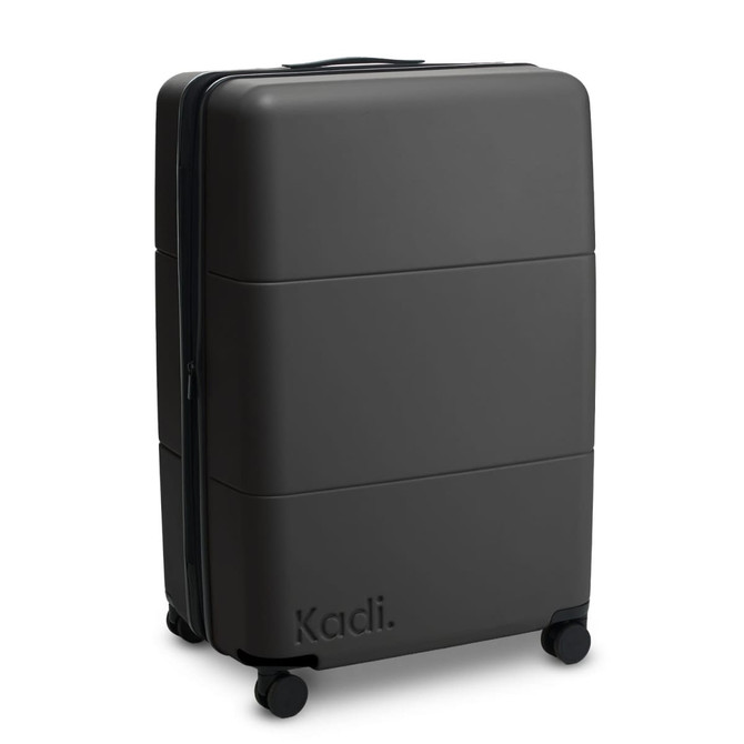 A large black suitcase with a smooth exterior and wheels, featuring a brand logo on the side.