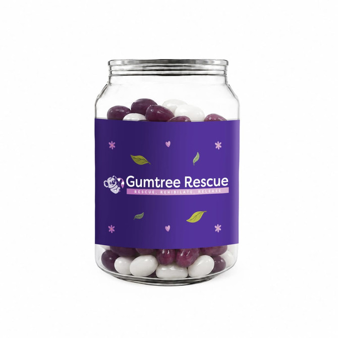 A clear canister filled with purple and white jelly beans, featuring a purple label with a logo.