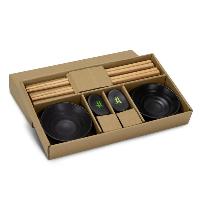 A sushi set featuring black bowls, bamboo chopsticks, and accompanying sauce dishes, presented in a cardboard box.