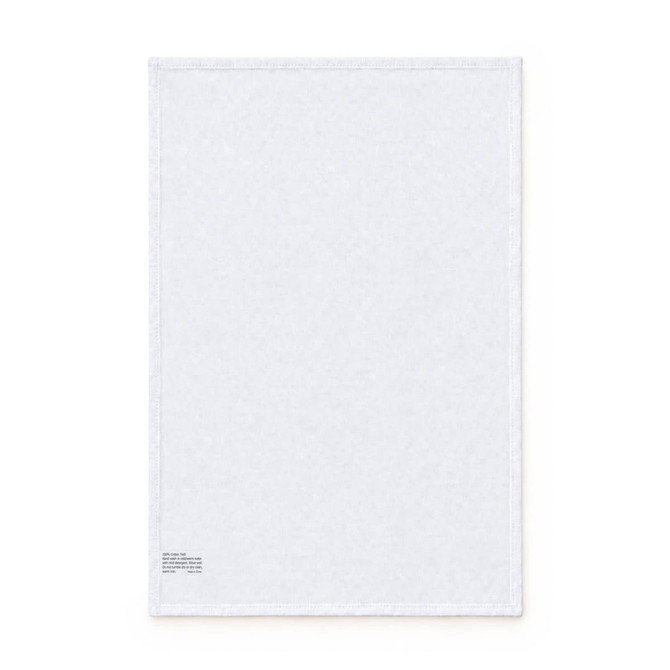 A white cotton tea towel featuring a stitched edge and a small logo in the corner.