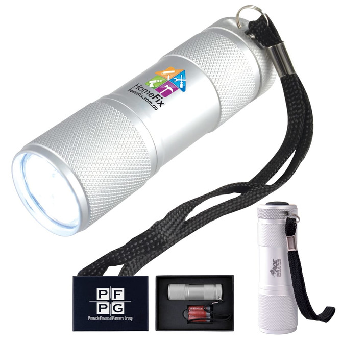 A silver flashlight with a textured grip, a keyring attachment, and a black lanyard, presented in a black box.