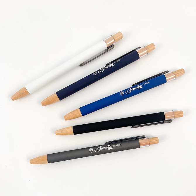 A set of Serenity Aluminium Pens in white, navy, blue, black, and grey, featuring wooden accents and a logo.