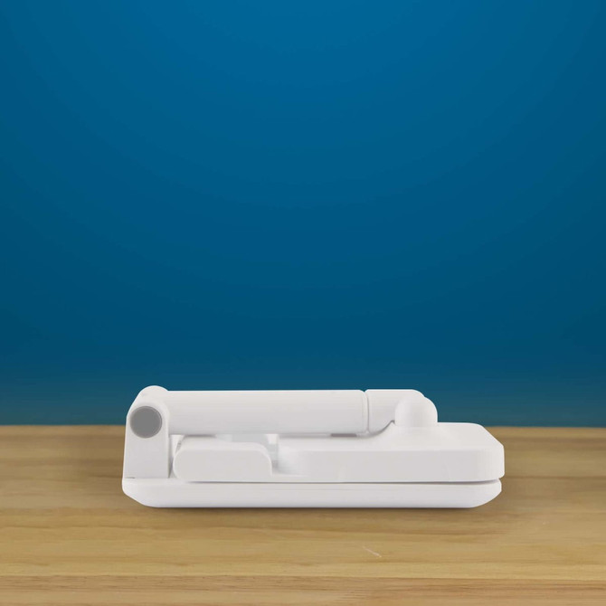 A Vectra Phone Stand in a sleek white design, positioned on a wooden surface against a solid blue background.