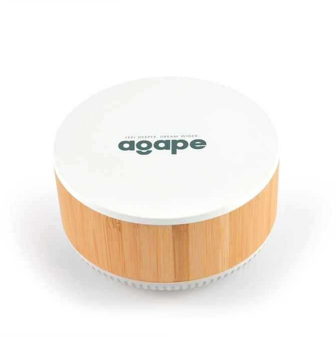 A round speaker and wireless charger with a white top and bamboo base, featuring a logo on the surface.