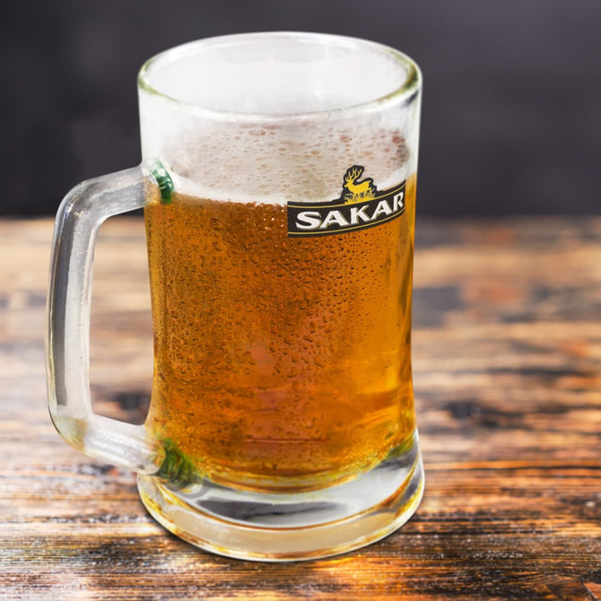 A glass beer mug filled with golden beer, featuring a frothy head and a logo on the front.
