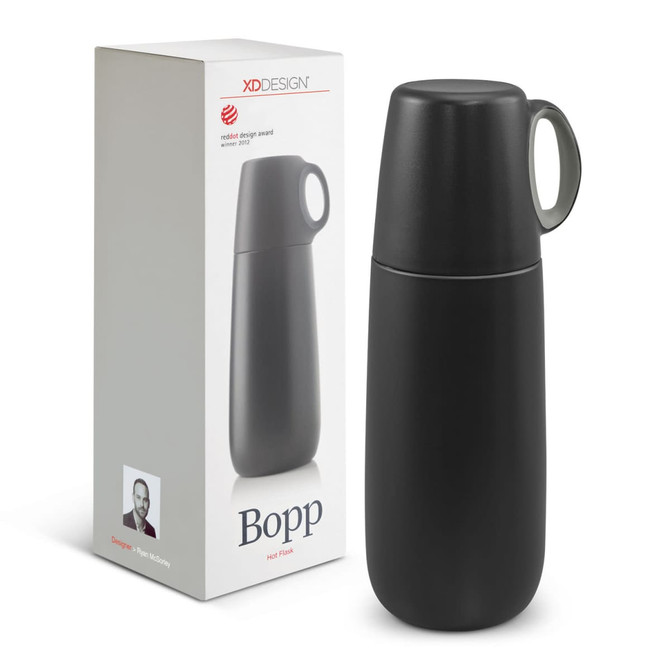 A drink bottle in matte black with a green handle, alongside its packaging featuring a logo.