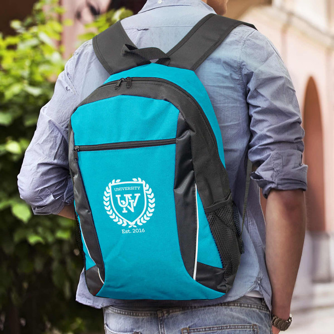 A teal and black backpack with a logo, being worn on someone's back outdoors.