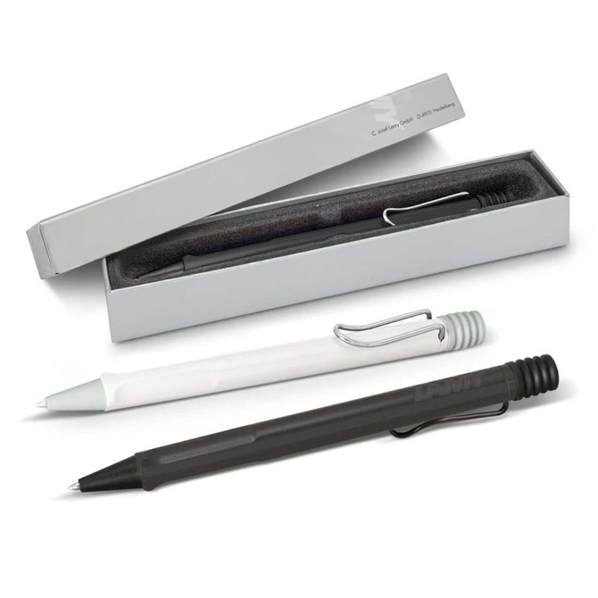 A collection of Lamy Safari pens in black, green, and white, displayed in a box with a soft interior.