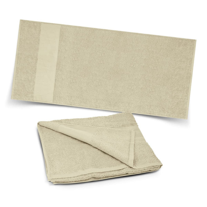 A sandy beige Dune Beach Towel, featuring a soft, textured surface and a plain section with branding.