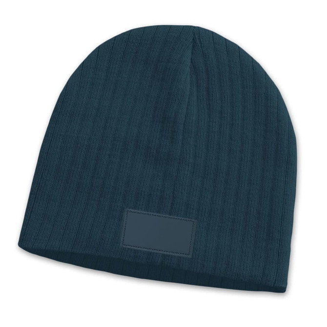 A teal cable knit beanie featuring a patch, displaying a textured design.