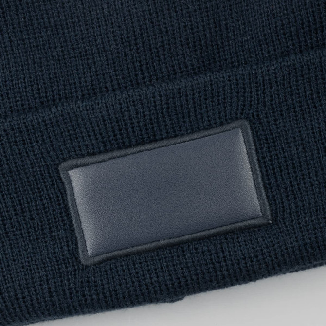 A dark beanie featuring a rectangular patch.