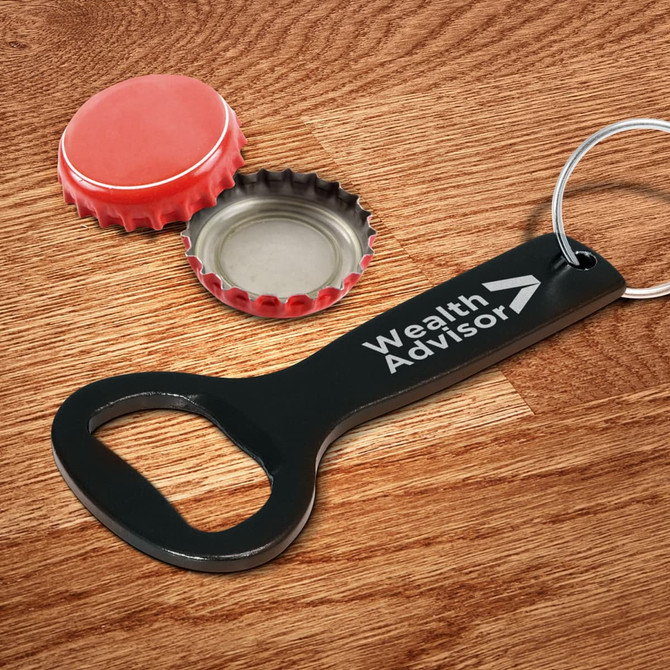 A drink bottle opener key ring in black, with a red bottle cap beside it and a metallic cap inside.