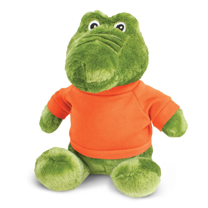 A green crocodile plush toy wearing an orange shirt, featuring large eyes and a friendly expression.