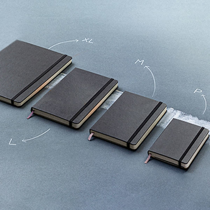 A set of Moleskine Classic Hard Cover Notebooks in varying sizes, featuring black covers and elastic closures.