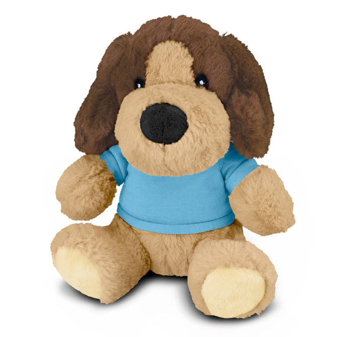 A plush dog toy with brown and tan fur, wearing a blue shirt, and a friendly expression. It has a branding logo.