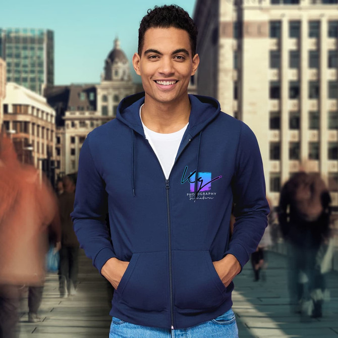 A navy blue unisex hooded sweatshirt with a front zipper and a logo. The model is smiling while posing outdoors.