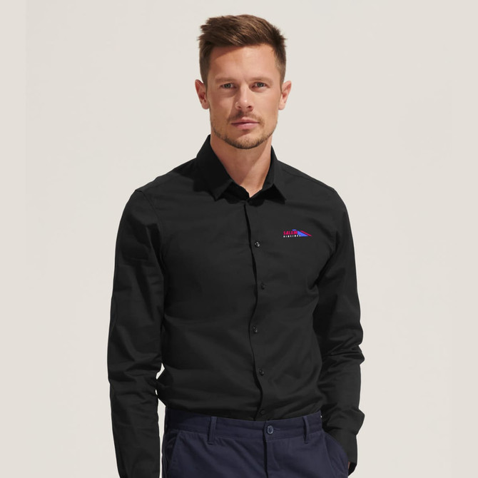 A black long sleeve button-up shirt with a logo on the chest. The model is standing against a neutral background.