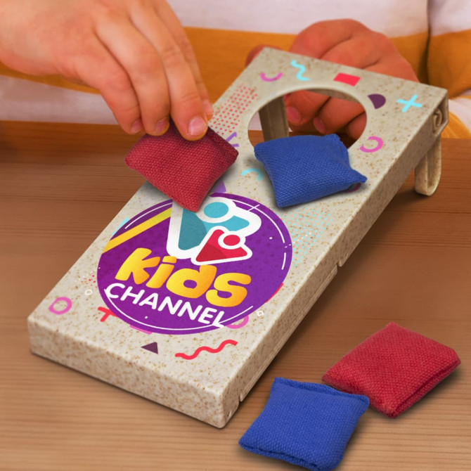 A cornhole game set with a speckled box design and red and blue bean bags, featuring a logo on the front.