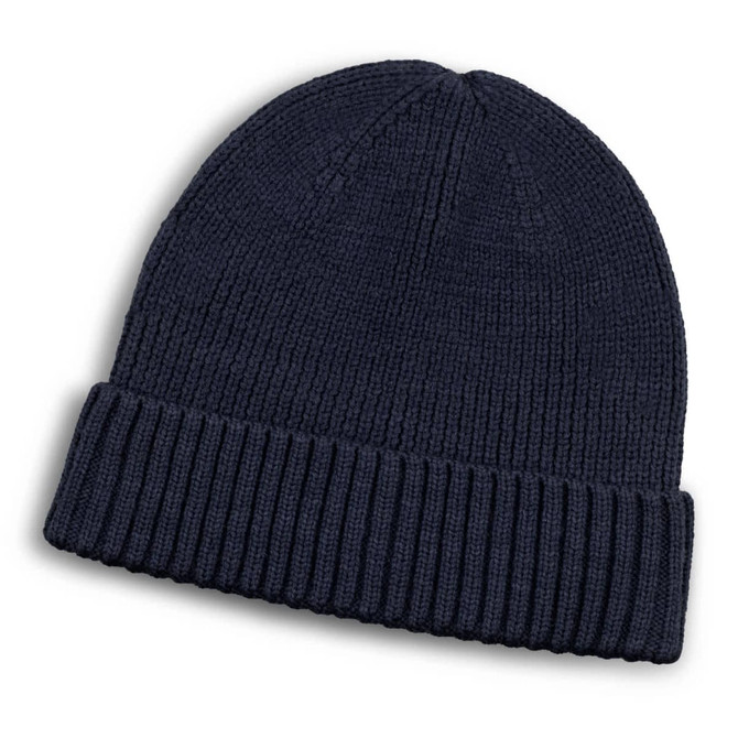 A navy blue merino wool beanie with a ribbed design and a folded cuff. It features a small logo.