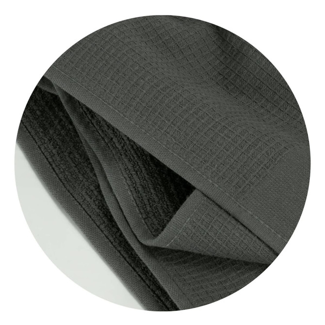 A dark grey waffle towel with a textured surface, featuring a folded design. It has a branding logo.