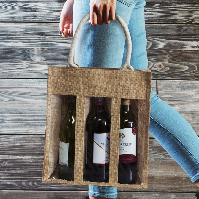 A jute tote bag in brown, carrying three wine bottles, with handles for easy transport. The bag has a logo.