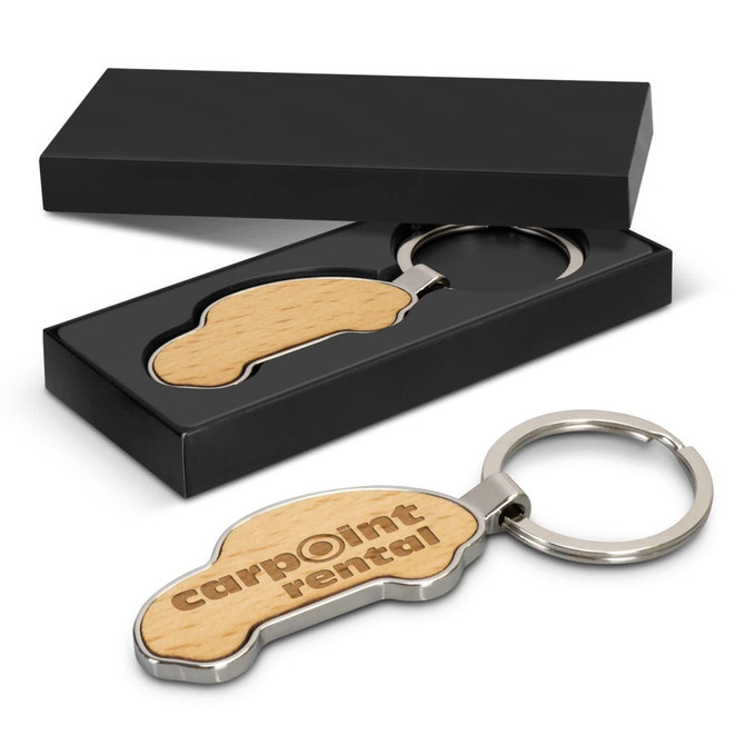 A car-shaped wooden key ring with a metal ring, presented in a sleek black box.