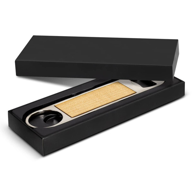 A drink bottle opener in a black box, featuring a metallic opening mechanism and a textured, gold-coloured grip.