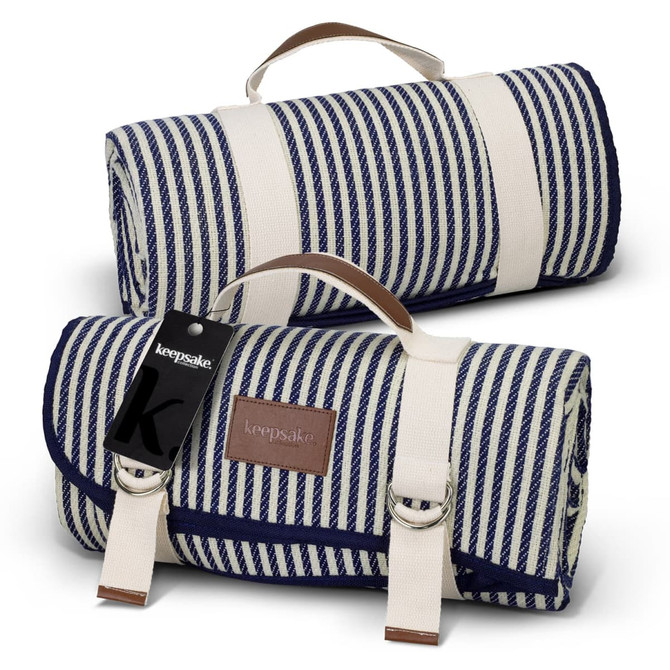 A blue and white striped picnic blanket rolled up, featuring a carrying handle and a logo tag.