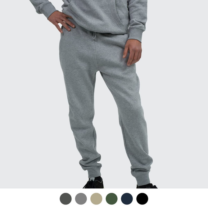 A person wearing grey unisex sweatpants with a relaxed fit, featuring an elastic waistband and cuffed ankles.