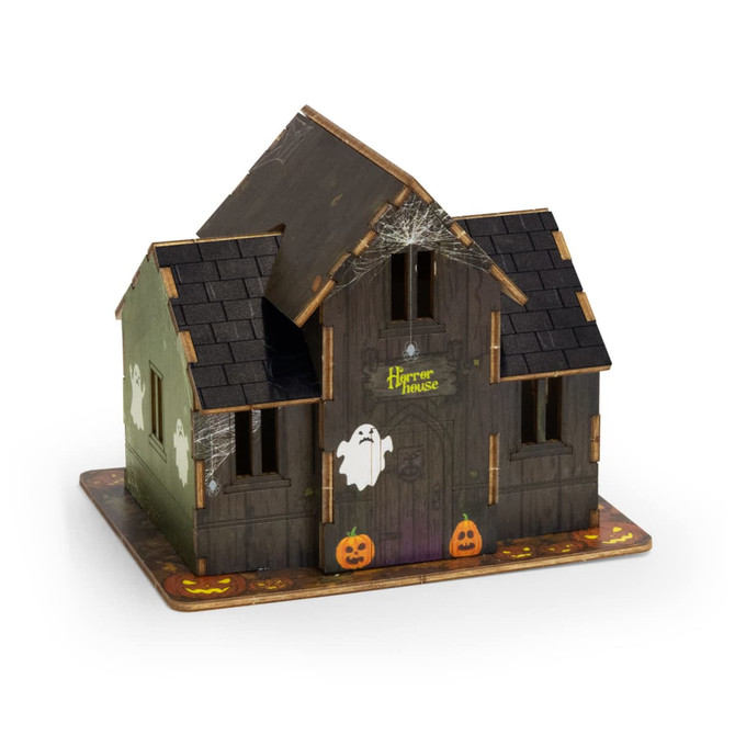 A wooden model of a spooky house in dark colours, featuring ghosts and pumpkins, with a logo on the front.