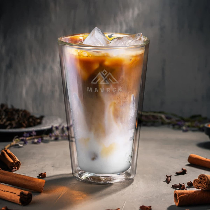 A drink bottle featuring a clear design with iced coffee and milk, surrounded by cinnamon sticks and spices.
