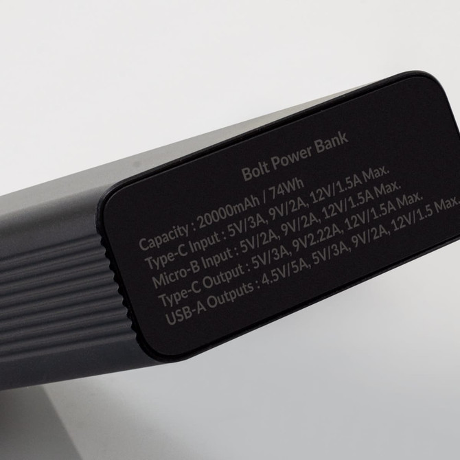 A black power bank with a sleek design, featuring a logo and specifications on one side.