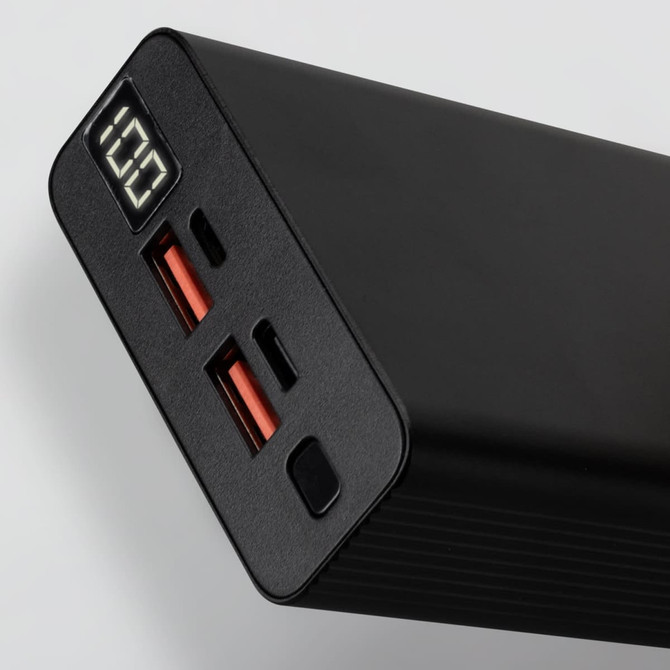 A black power bank with two USB ports, one USB-C port, and a digital display showing battery percentage.