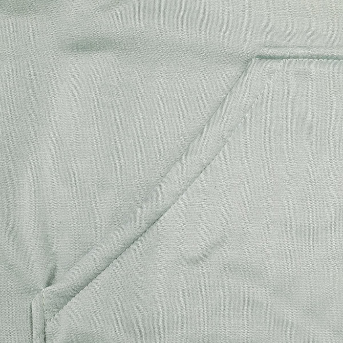 A close-up of a light green fabric featuring a seamless pocket, part of a hoodie design.